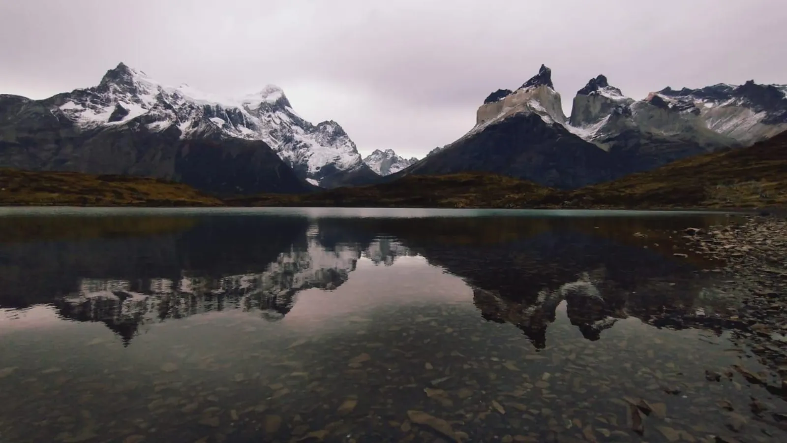 The Cuernos del Paine reflected in a still lake at dusk