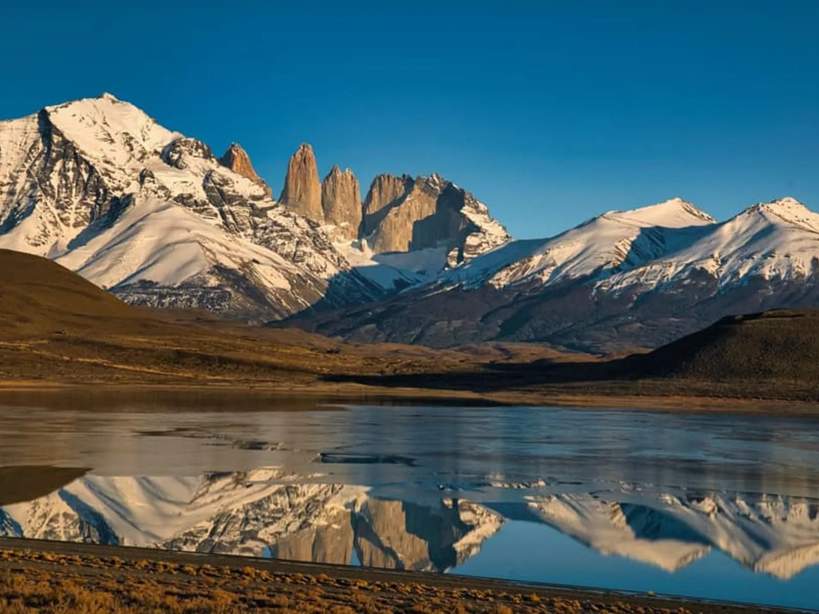 The towers and snowy peaks mirrored in a still lagoon